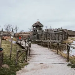 Drewniany most prowadzi do grodu z wieżą strażniczą, odtworzonego na szlaku piastowskim.