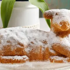 Ein süßer Osterlamm-Kuchen, mit Puderzucker bestäubt, symbolisiert die Bedeutung von Ostern und Neuanfang.