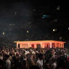 Stor publik på en konsert i Strawberry Arena. En rosa byggnad med gula detaljer står på scenen.