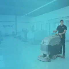 Un vendedor muestra equipos de limpieza industrial a dos clientes.