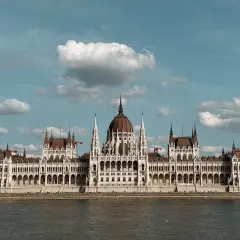 Majestatyczny Parlament w Budapeszcie i okolice, odbijający się w spokojnej wodzie Dunaju.