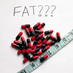 Kapsułki i miarka, a nad nimi napis "FAT???". Czy johimbina co to pomoże zrzucić zbędne kilogramy?