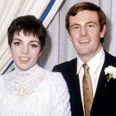 Liza Minnelli och hennes make på bröllopsdagen. Hon bär en vit spetsklänning och han en mörk kostym med en vit nejlika.