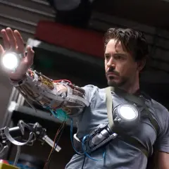 Tony Stark, w którego wciela się Robert Downey Jr. (iron man obsada), testuje nową rękawicę z repulsorami.