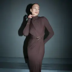 Elegancka, brązowa sukienka maxi z golfem i drapowaniem podkreśla sylwetkę. Długość sukienki do wzrostu modelki jest idealna.