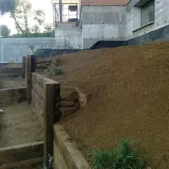 Costruzione di terrazzamenti con travi di legno per livellare pavimento in pendenza.
