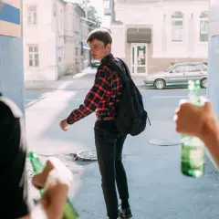 Młodzi ludzie z butelkami piwa. Pamiętaj, co grozi za picie alkoholu w wieku 17 lat.