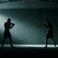 Two boxers spar in a dimly lit gym, bathed in light from a window. Perhaps this is where the peek a boo style was invented.