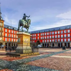 Plaza Mayor de Madrid, con estatua ecuestre y edificios rojos. Imagina llegar en tren santiago madrid y ver esta maravilla.