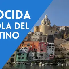 Procida, l'isola del postino, con le sue case colorate a picco sul mare e la cupola della chiesa che domina il panorama.