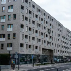 Nowoczesny budynek mieszkalny z balkonami. Zastanawiasz się, jak sprawdzić, czy mieszkanie jest zadłużone? Warto sprawdzić księgę wieczystą.