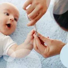 Delikatne obcinanie paznokci niemowlakowi wymaga precyzji. Rodzic ostrożnie używa małych nożyczek, by zadbać o dłonie maluszka.