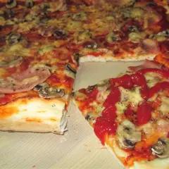 Domowa pizza z pieczarkami i szynką, polana ketchupem. Idealna inspiracja, jak zrobić pizzę, która zachwyci każdego.