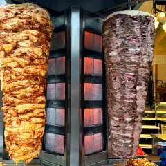Dwa pionowe rożny z mięsem do kebaba, jeden z kurczaka, drugi wołowy. Zastanawiasz się, ile kcal ma mały kebab?