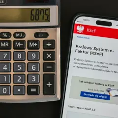 Kalkulator i smartfon z ekranem wyświetlającym Krajowy System e-Faktur (KSeF).
