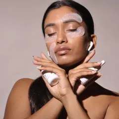 Donna con cerotti per il contorno occhi e creme, per combattere il viso stanco. Rimedi di bellezza per un aspetto radioso.