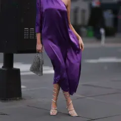 Eleganckie, srebrne sandałki na obcasie idealnie pasują do fioletowej sukienki. To świetna inspiracja, jakie buty do fioletowej sukienki wybrać na wieczór.