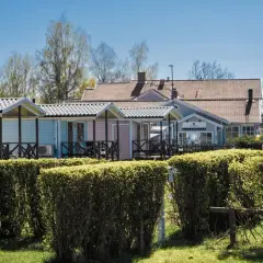 Färgglada stugor och reception vid Villa Björkhagen, Jönköping. En husbil syns till höger.