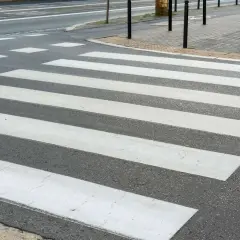 Lignes blanches sur l'asphalte, un passage piéton invite à traverser la rue en toute sécurité.