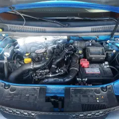 Motor de Dacia Sandero GLP con mangueras de gas y batería. Posibles problemas de instalación o mantenimiento.