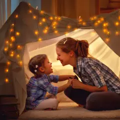 Mama i córka w namiocie z lampek, śpiewają piosenki o mamie.