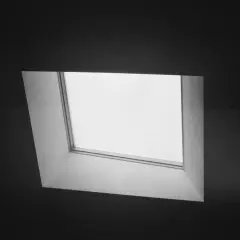 Szare, uchylne okno w ciemnej ścianie.
