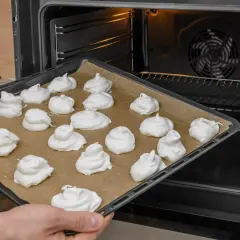 Taca z bezami gotowa do pieczenia. Idealna temperatura pieca bezy to klucz do ich chrupkości.