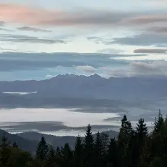 Mglisty poranek na Turbaczu. Wschód słońca maluje niebo pastelowymi barwami nad morzem chmur, a w oddali majaczą Tatry.