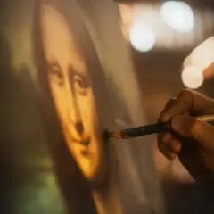 Dłoń artysty dopracowuje słynny obraz Leonarda da Vinci, Mona Lisę, dodając ostatnie pociągnięcia pędzlem.