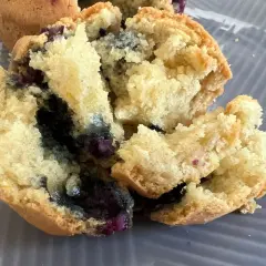 Muffin ai mirtilli appena sfornati nella friggitrice ad aria, con interno soffice e mirtilli succosi.