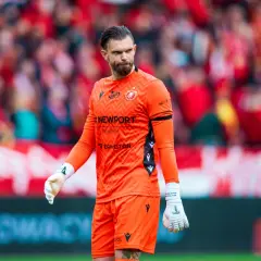 Bramkarz w pomarańczowym stroju na tle kibiców. Radomiak Radom – Widzew Łódź – statystyki meczu.