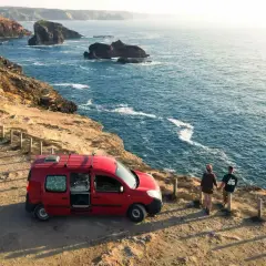 Para podróżuje kamperem po Portugalii, podziwiając skaliste wybrzeże i ocean.