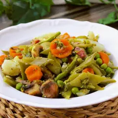 Deliciosa menestra de verduras receta, con judías verdes, zanahoria, guisantes y champiñones, todo aderezado con una salsa verde.