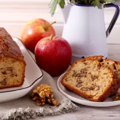 Un délicieux gâteau aux pommes et noix de grand-mère, avec des tranches présentées sur une assiette.