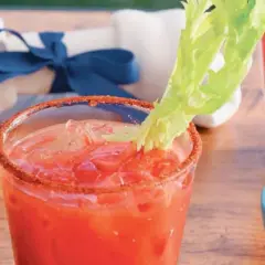 Orzeźwiający krwawy mary drink z lodem, ozdobiony łodygą selera i przyprawionym brzegiem szklanki.