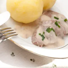 Bamberger Krenfleisch mit Klößen und einer cremigen Soße, garniert mit Schnittlauch. Ein deftiges Gericht.