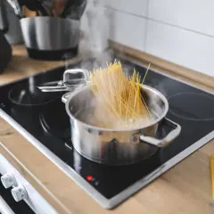 Spaghetti kochen in einem Topf auf dem Herd. Die Frage "wieviel pasta pro person hauptgericht" beschäftigt viele Hobbyköche.