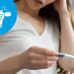 Kobieta z niepokojem patrzy na test ciążowy. Ikona symbolizuje problemy z płodnością, takie jak endometrioza a ciąża.