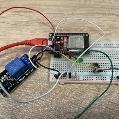 Układ do nauki, jak podłączyć przekaźnik: moduł ESP32, płytka stykowa, przekaźnik 1-kanałowy, przycisk i dioda LED.