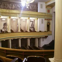 Wnętrze teatru im. H. Modrzejewskiej z portretami aktorek i malowidłem na ścianie.