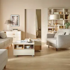 Jak ustawić meble w pokoju program? Jasny salon z sofą, fotelem, stolikiem kawowym i regałem.