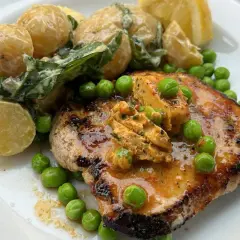 En saftig biff med café de Paris-smör, serverad med krämiga potatisar och gröna ärtor. En klassisk rätt som smakar som en solig dag i Paris.