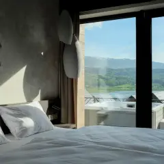 Pokój w hotelu Lake Hill z widokiem na jezioro i góry. Wanna z hydromasażem na tarasie.