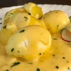 Senfeier rezept: pochiere Eier in cremiger Sauce mit Kartoffeln und einem frischen Gurkensalat.