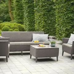 Relaks na tarasie w stylu boho: wygodna sofa, fotele, stolik kawowy z przekąskami i napojami, otoczone zielenią.