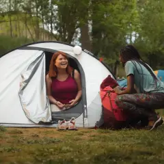 Dwie kobiety rozmawiają przy namiocie. Idealne miejsce, gdzie pod namiot z dziećmi w Polsce, by cieszyć się naturą.