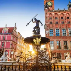 Neptunfontänen i Gamla stan i Gdansk, med sina färgglada hus och ett imponerande tegelhus med klocktorn.