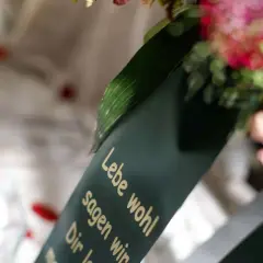 Trauerkranz mit Spruch "Lebe wohl". Mögliche Nachteile beim Kirchenaustritt für die Beerdigung.