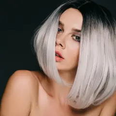 Kobieta z czarnymi włosami przechodzącymi w modny ombre blond.