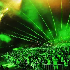 Tłum ludzi na festiwalu **Audiolake** pod zielonymi laserami i światłami.